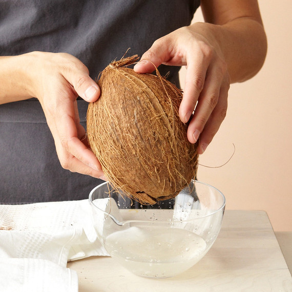 Hände holding coconut bowl water