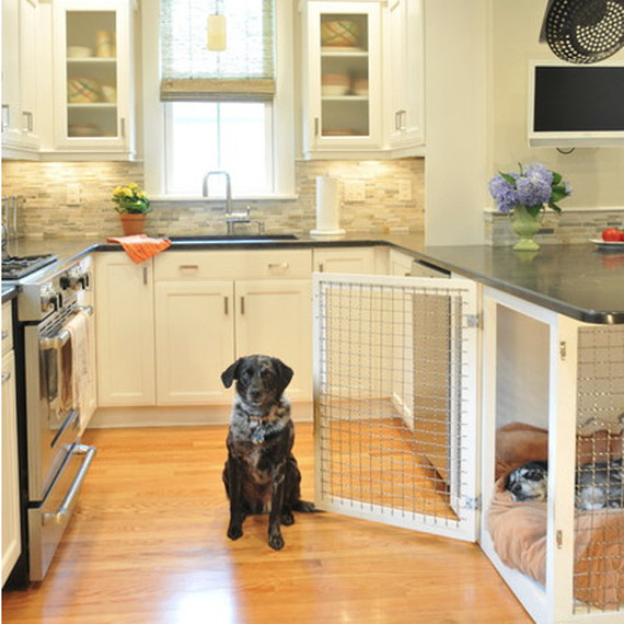 Това dog house is built into the counter space of the kitchen.