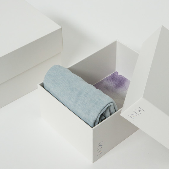 bílý marie kondo box with clothes folded in it