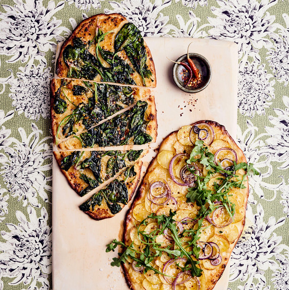 römisch thin-crust pizzas with kale, arugula, and onion