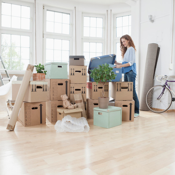 女人 unpacking boxes in new apartment