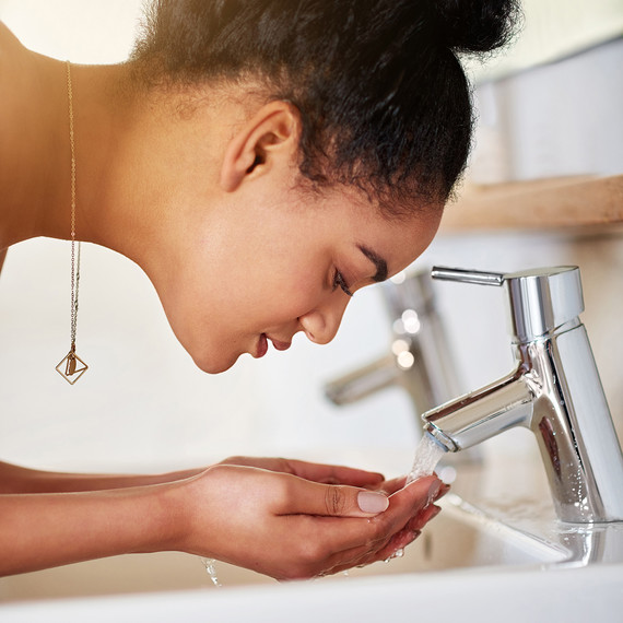 女人 washing face at sink